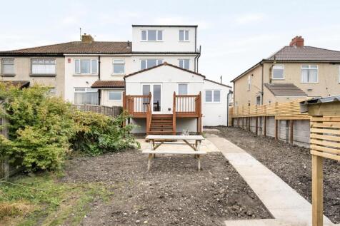 A spacious and well-lit garden area with a deck...