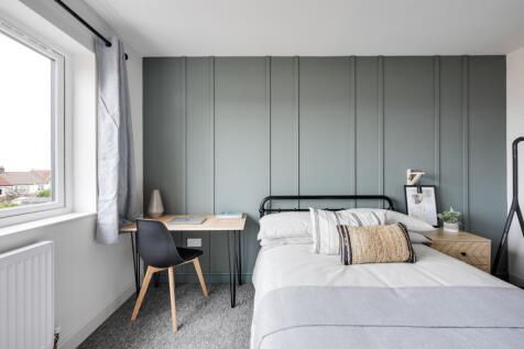 A clean and well-lit double bedroom featuring a...