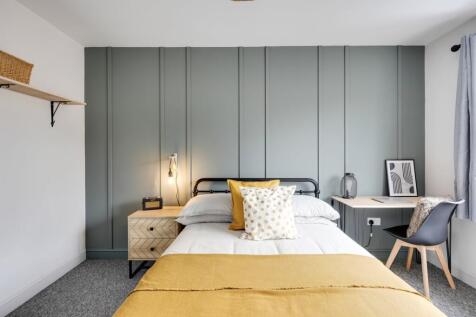 A clean and inviting double bedroom with stylis...