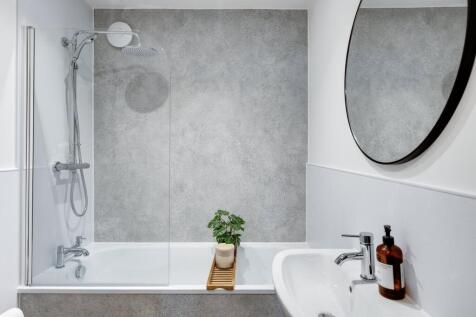 A modern and clean bathroom featuring a shower,...