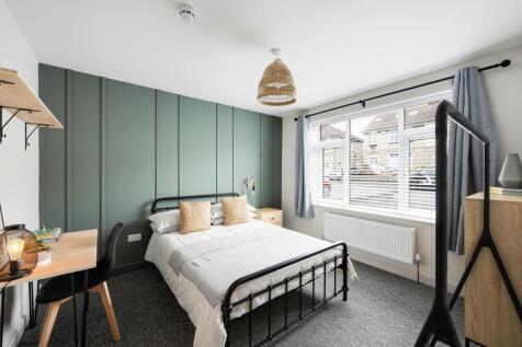 Bright, stylish bedroom with a painted feature ...