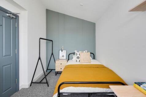Bright, neatly styled single bedroom with a mus...