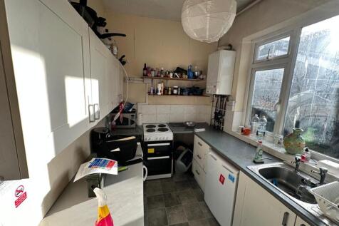 A bright kitchenette with ample storage and wor...