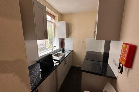 Compact galley-style kitchen with dark speckled...