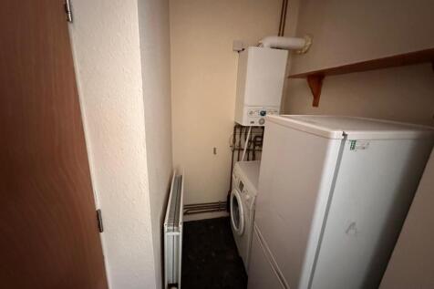 Compact utility/storage room with fitted radiat...