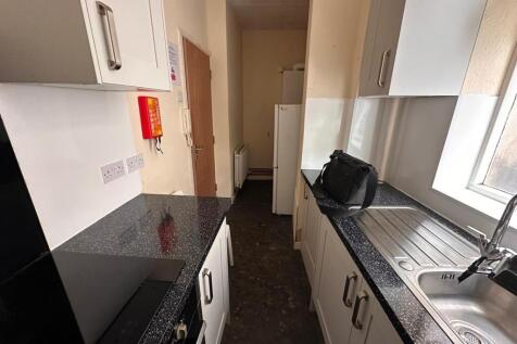 Bright galley kitchen with modern speckled work...