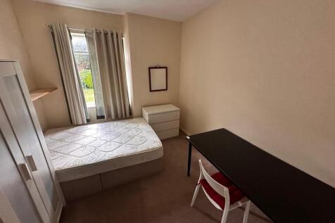Bright, simply furnished single bedroom with a ...