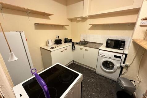 Compact fitted kitchen with white cabinets, int...