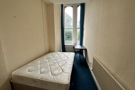 Neat, narrow bedroom with a single bed position...