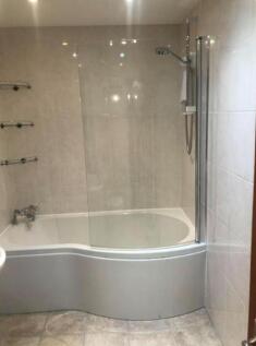 A spacious and modern bathroom featuring a styl...