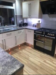 A modern and well-lit kitchen featuring stylish...