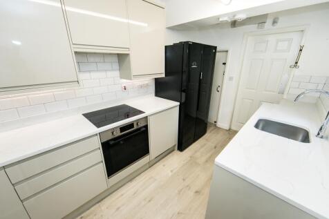 A bright and clean kitchen featuring modern whi...