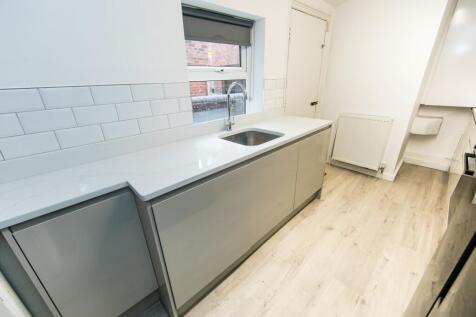 A modern, well-lit kitchen with clean, sleek su...