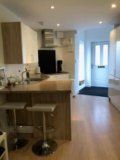 Modern open-plan kitchen with a breakfast bar a...