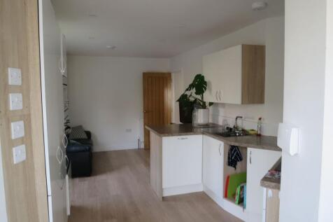 Bright open-plan kitchen with light wood floors...