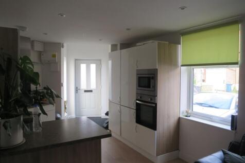 Bright, modern kitchen with integrated oven and...