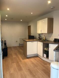 Bright, modern open-plan kitchen with warm wood...