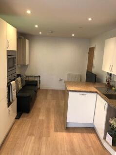 Bright modern kitchen with wood-effect flooring...