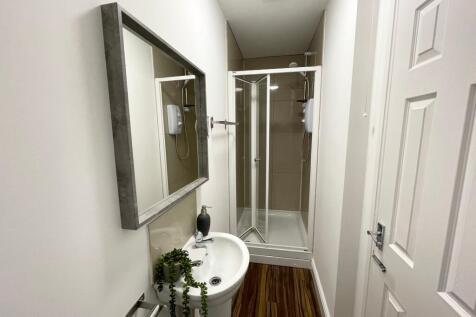Bright, modern bathroom with a corner shower cu...