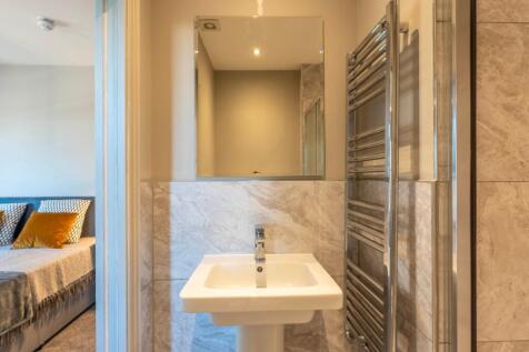 Modern bathroom with a pedestal sink, wall-moun...
