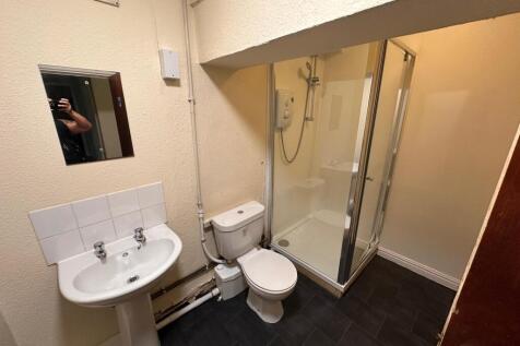 Clean ensuite bathroom with a corner shower cub...