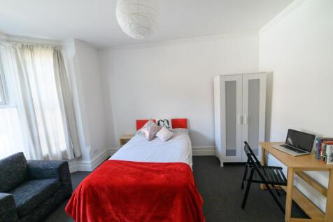 Bright, simply furnished bedroom with a comfort...