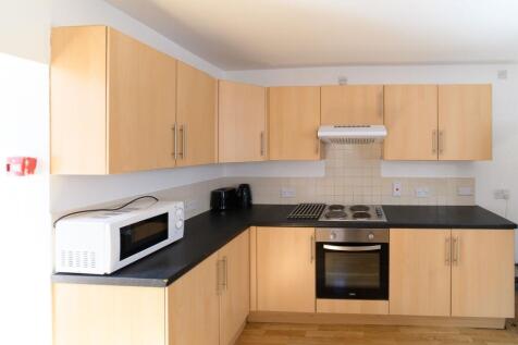 Bright, modern kitchen with light wood cabinets...