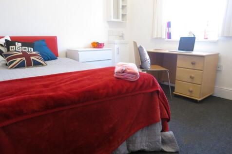 Bright, neatly arranged bedroom with a comforta...