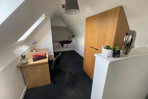 Bright attic single bedroom with a study desk b...