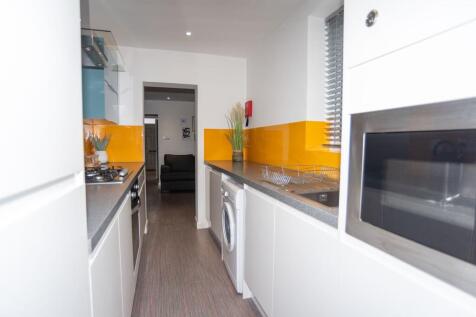 Bright, modern galley kitchen with sleek white ...