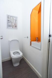 Bright, modern WC with a clean white suite, con...