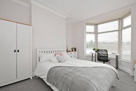 Bright, neatly styled double bedroom with a com...