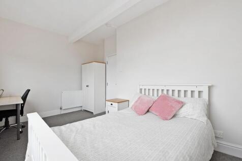 Bright, neatly presented bedroom with a white b...
