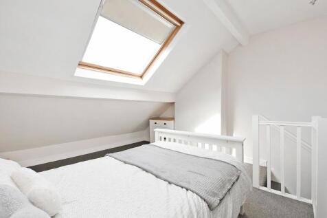 Bright, freshly painted attic bedroom with a la...