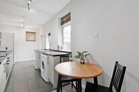 Bright galley kitchen with modern white cabinet...
