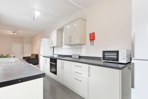 Bright modern galley kitchen with sleek cream c...