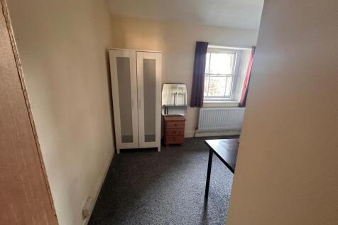 Simple, neutrally decorated bedroom with a ward...