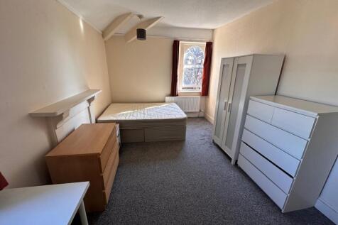 Bright, simply furnished bedroom with a single ...