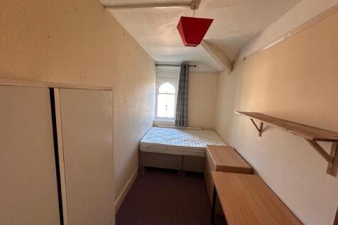 Long single bedroom with a raised single bed at...