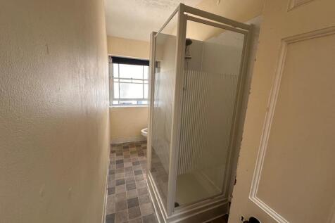 Narrow bathroom with a shower cubicle and natur...