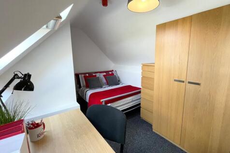 Bright, neatly furnished bedroom with a comfort...