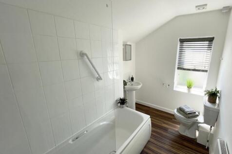 Bright, modern bathroom with a full bath and gl...