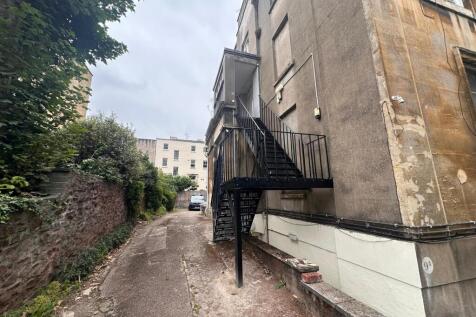 Rear access lane beside a period building with ...