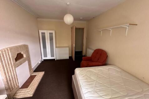 Bright, long bedroom with neutral walls, fitted...