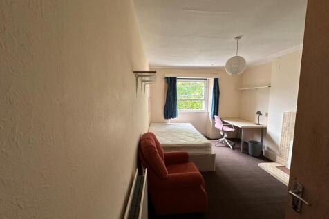 Bright furnished bedroom with a large window, c...