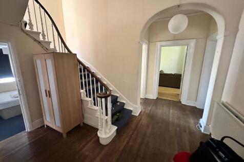 Spacious entrance hallway with a curved stairca...
