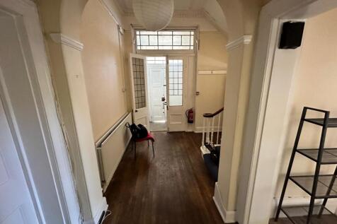 Bright entrance hallway with high ceilings, dec...