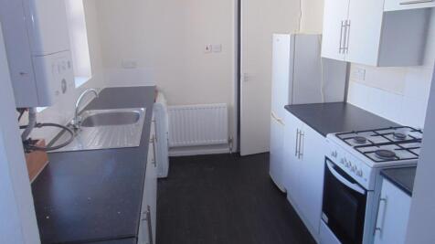 Neat galley kitchen with dark worktops, stainle...