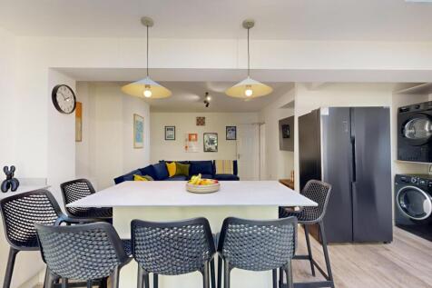 A spacious, well-lit living room featuring mode...