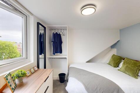 A tidy and well-lit single bedroom featuring a ...